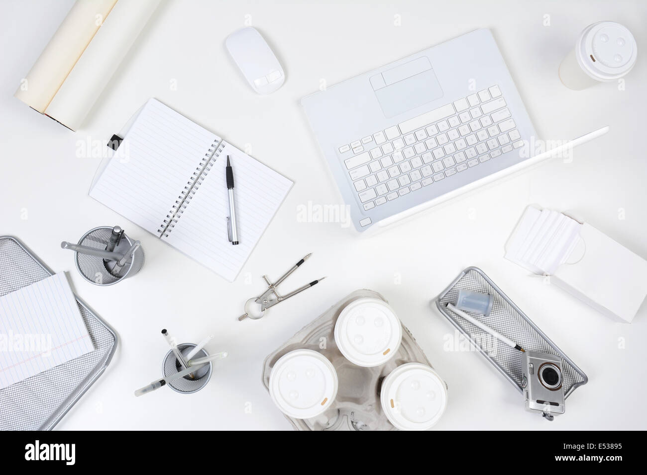 Hohen Winkel Schuss aus einem weißen Schreibtisch mit vorwiegend weißer und silberner Office-Objekte. Elemente enthalten, Laptop-Computer, Pad, Stifte Stockfoto