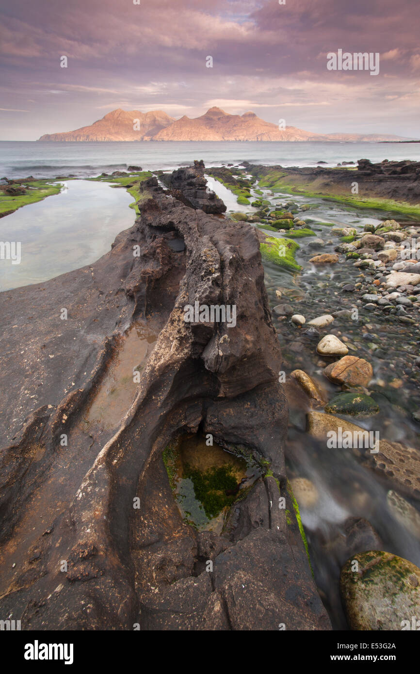 Vulkanische Felsformationen in der Nähe von Laig Bay, Insel Eigg mit Blick auf die Isle of Rum, kleinen Inseln, Inneren Hebriden, Schottland, U Stockfoto