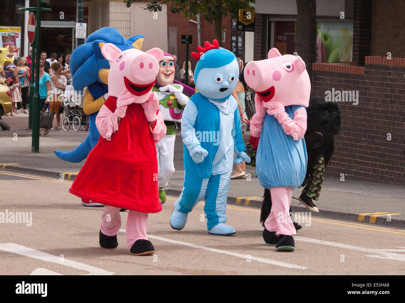 Zwei Peppa Pig Zeichen und Iggle Piggle von In the Night Garden gehen in Prestatyn Karnevalsumzug in Wales, UK Stockfoto