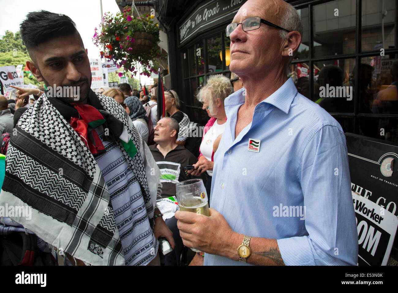 London, UK. Samstag, 19. Juli 2014. Pro-palästinensische Demonstranten in die Zehntausende marschieren durch die Londoner an die israelische Botschaft aus Protest gegen die militärische Offensive im Gazastreifen durch Israel. Britische Demonstrant hat einen Pint vor einem Pub, wie Demonstranten passieren. Bildnachweis: Michael Kemp/Alamy Live-Nachrichten Stockfoto