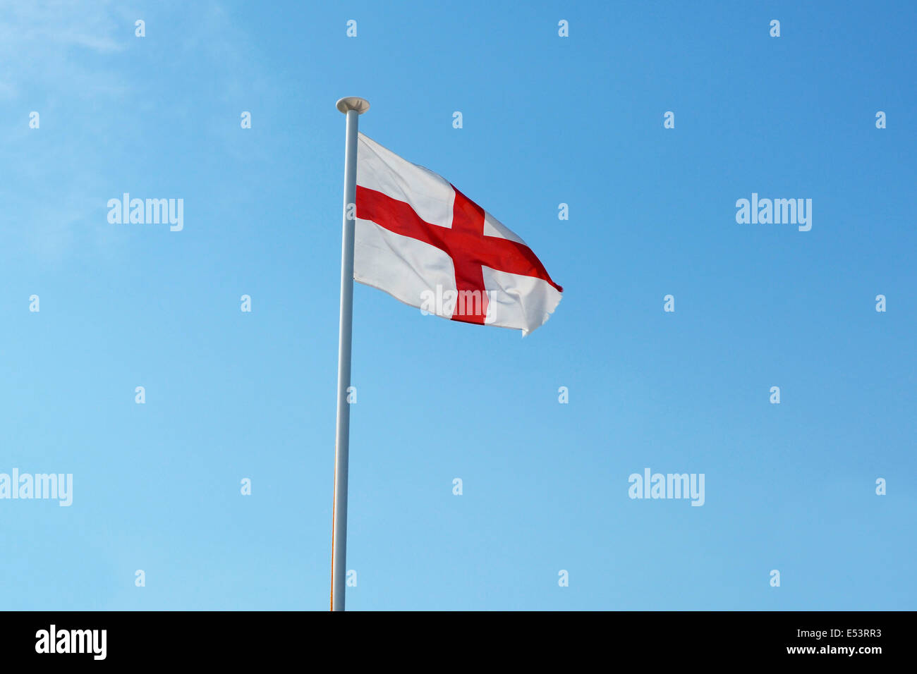 Die englische Nationalflagge, Str. Georges Kreuz, fliegen aus einer Fahnenstange gegen ein strahlend blauer Himmel Stockfoto