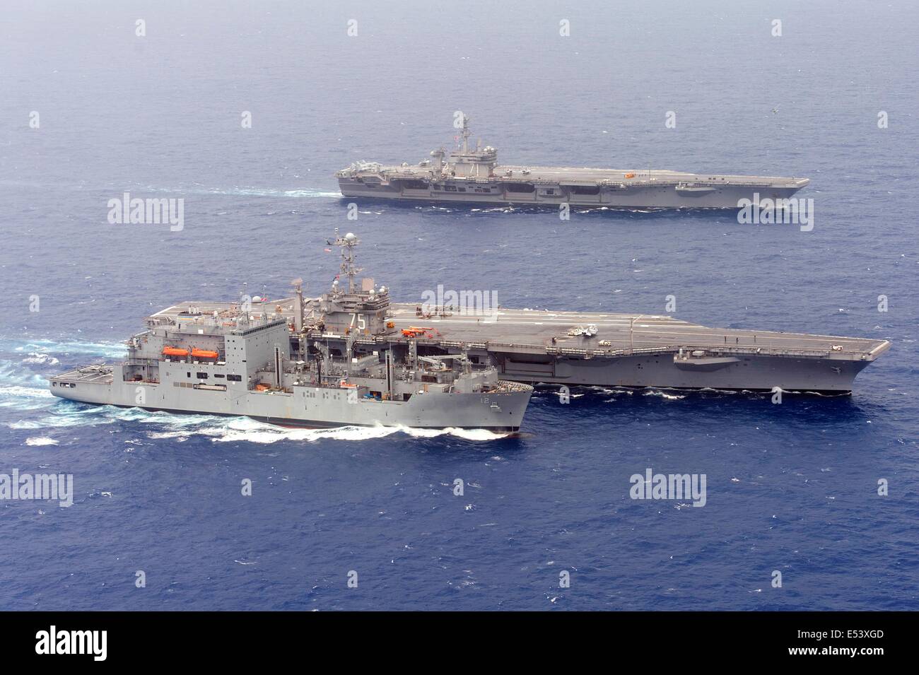 US Navy Nimitz-Klasse-Flugzeugträger USS Harry S. Truman nimmt Trockenfracht und Munition aus der USNS William McLean während einer Off-Load als Flugzeug-Träger USS Theodore Roosevelt folgt 16. Juli 2014 in den Atlantischen Ozean. Stockfoto