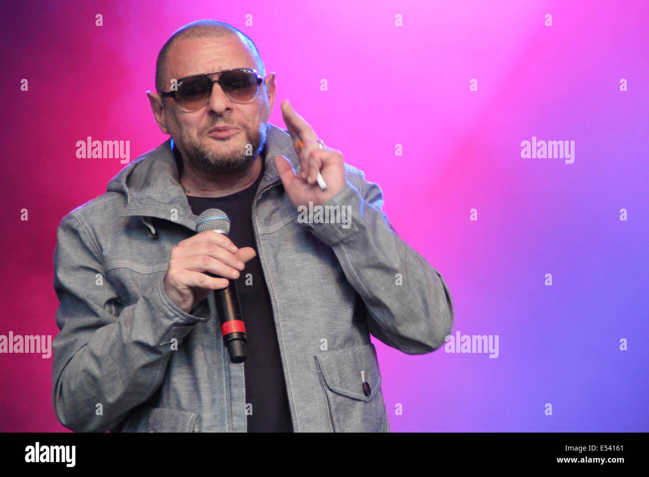 Nottingham East Midlands, UK.  19. Juli 2014.  Shaun Ryder raucht eine E-Zigarette, während live auf der Bühne mit den Happy Mondays Pracht-Festival auf dem Gelände des Wollaton Hall in Nottingham. Stockfoto