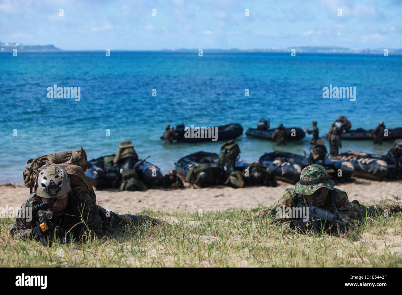 Japanischen Boden Selbstverteidigung und US-Marine Scout Schwimmer Sonderbetrieb Soldaten führen einen Strand landen beim üben kleine Maßeinheit Niveau Techniken im Rahmen des Austauschprogramms für Japan Beobachter am Kin Blue Beach 16. Juli 2014 in Okinawa, Japan. Stockfoto