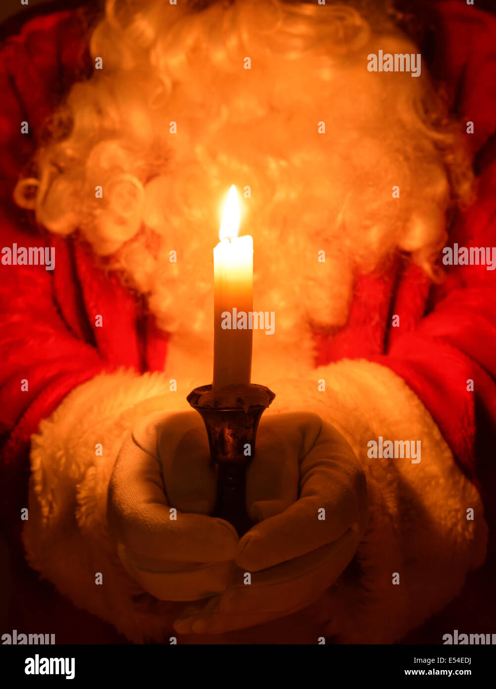 Weihnachtsmann hielt eine brennende Kerze in einem antiken Silber chamberstick Stockfoto