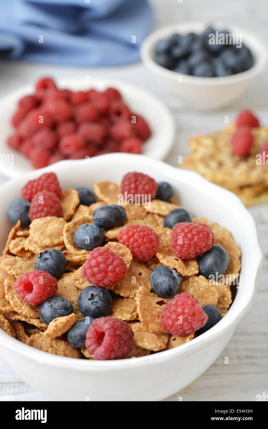 Vollkorn-Flocken in Schüssel mit frischen Beeren auf hellem Hintergrund Stockfoto