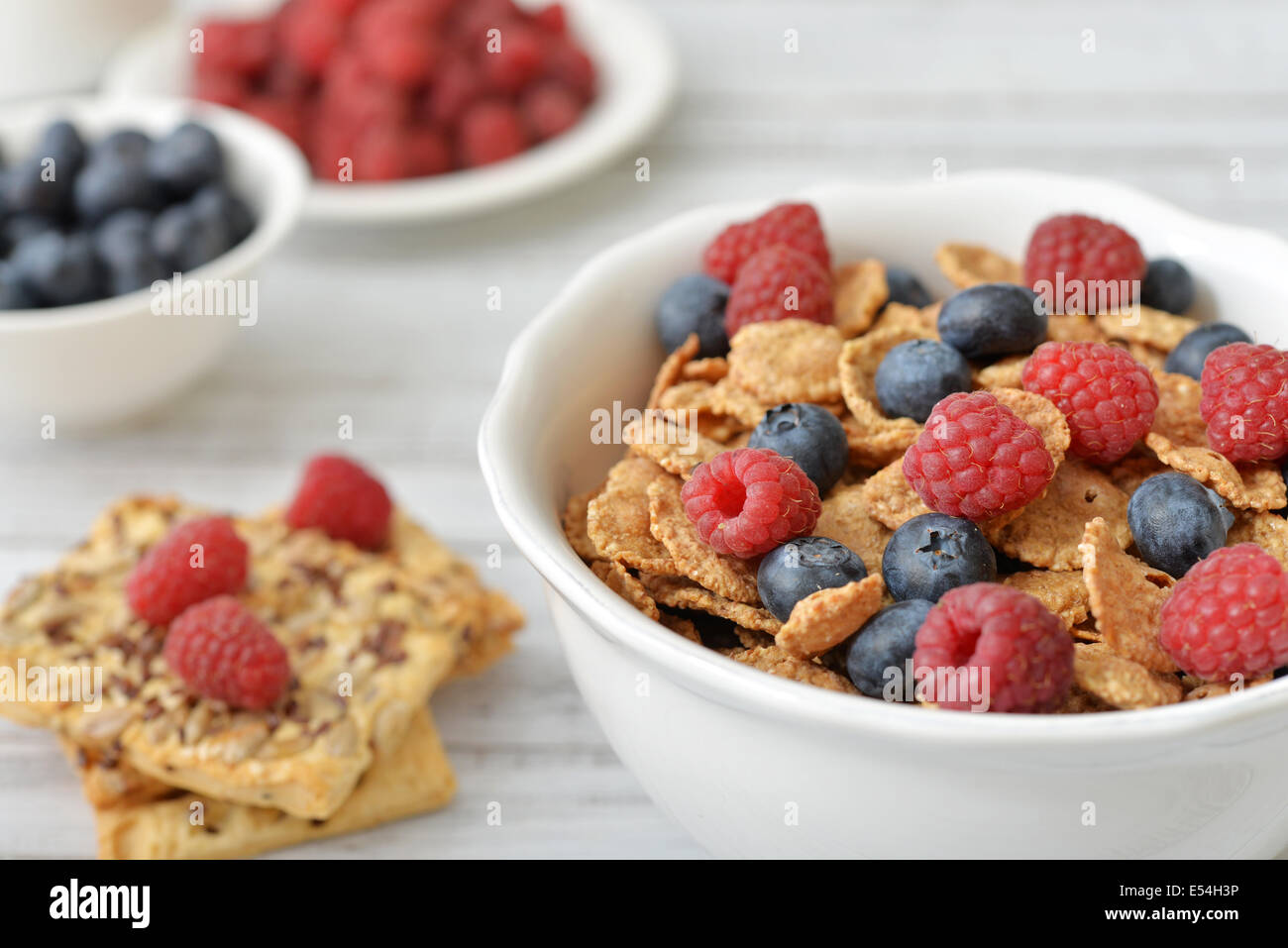 Vollkorn-Flocken in Schüssel mit frischen Beeren auf hellem Hintergrund Stockfoto