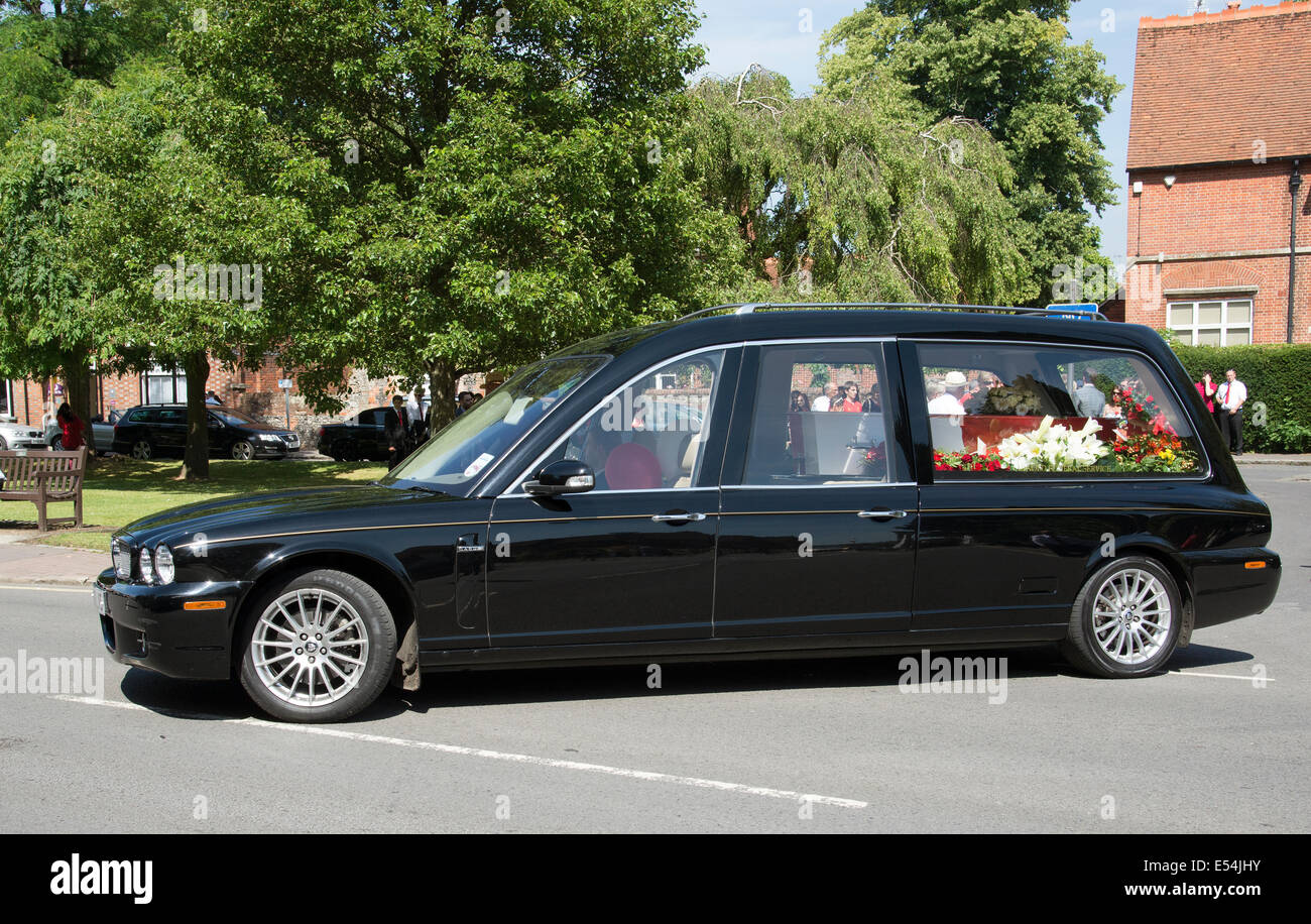 Jaguar-Leichenwagen tragen einen roten und weißen farbigen Sarg in einer Beerdigung Parade Marlow Buckinghamshire UK Stockfoto