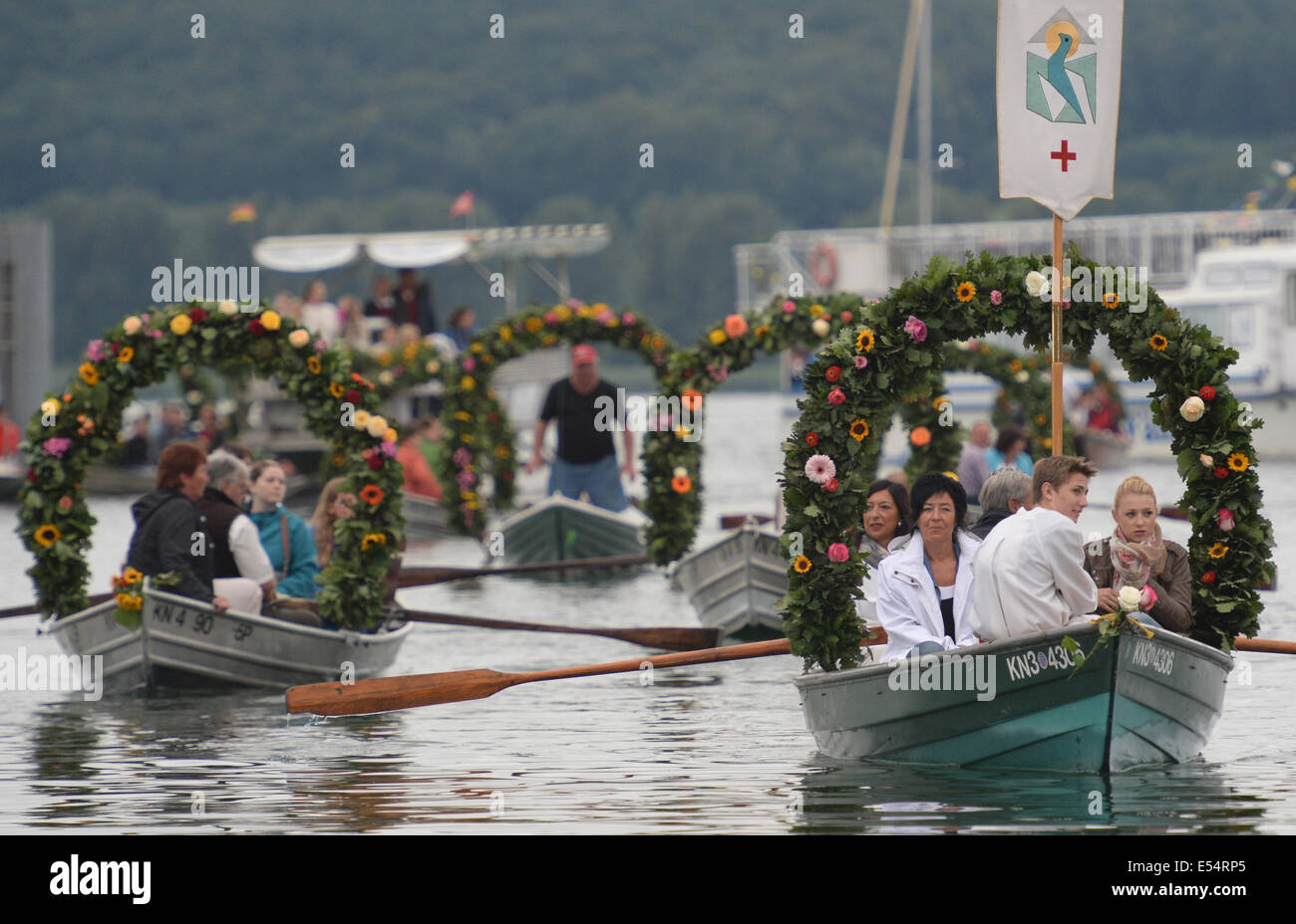 Radolfzell, Deutschland. 21. Juli 2014. Boote mit Blumenkränzen geschmückt Segel während der Wasser Prozession von Moos am Bodensee in den Hafen Radolfzell, Deutschland, 21. Juli 2014. Die Prozession findet jährlich am dritten Montag im Juli seit 1926 statt und ist eine Danksagung für die Schonung der Bürgerinnen und Bürger von Moos aus einer Rinderpest im Jahre 1796. Foto: Patrick Seeger/Dpa/Alamy Live News Stockfoto