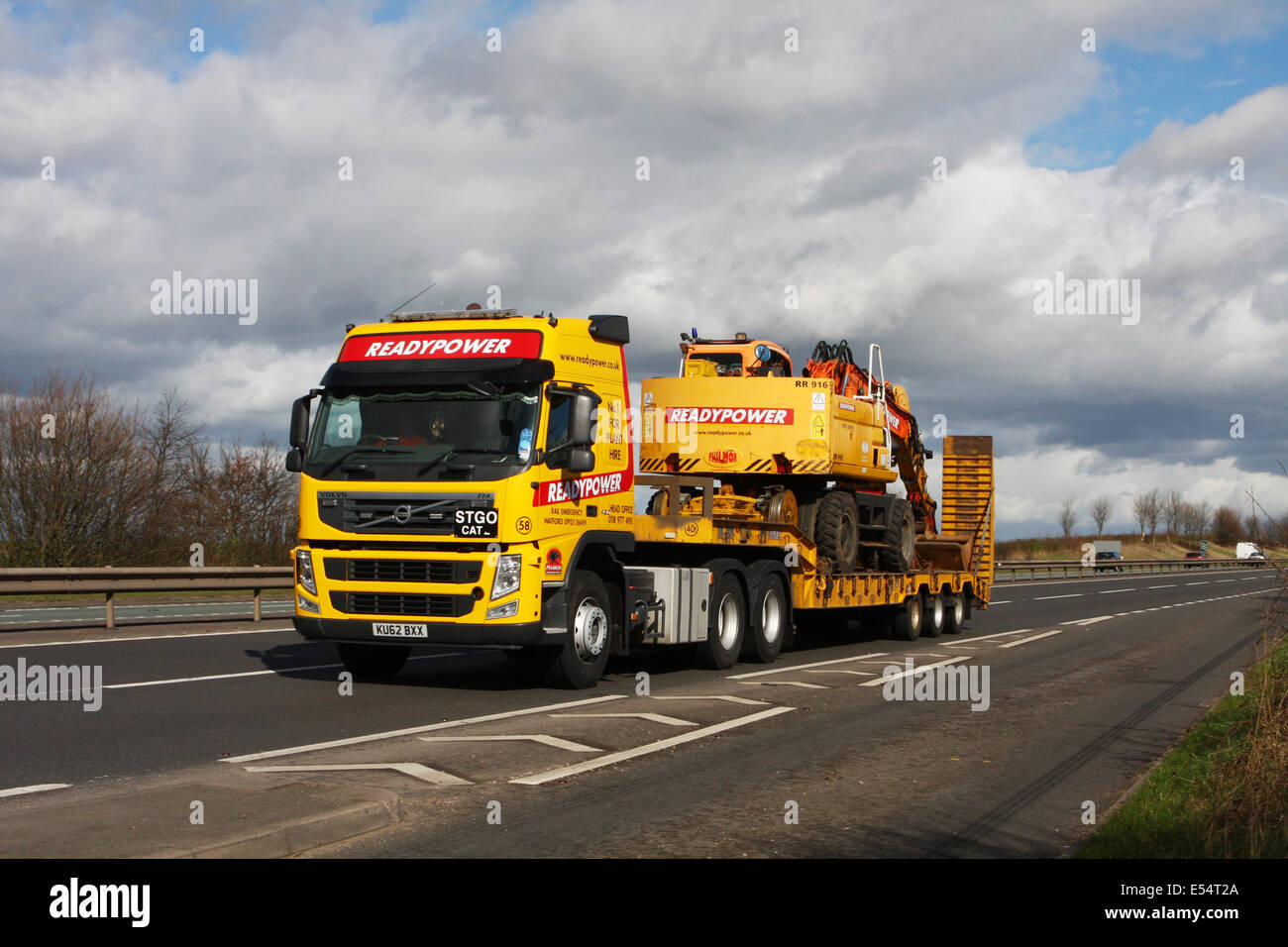 Readypower Tieflader ziehen einen Readypower Bagger entlang der Schnellstraße A46 in Leicestershire, England Stockfoto