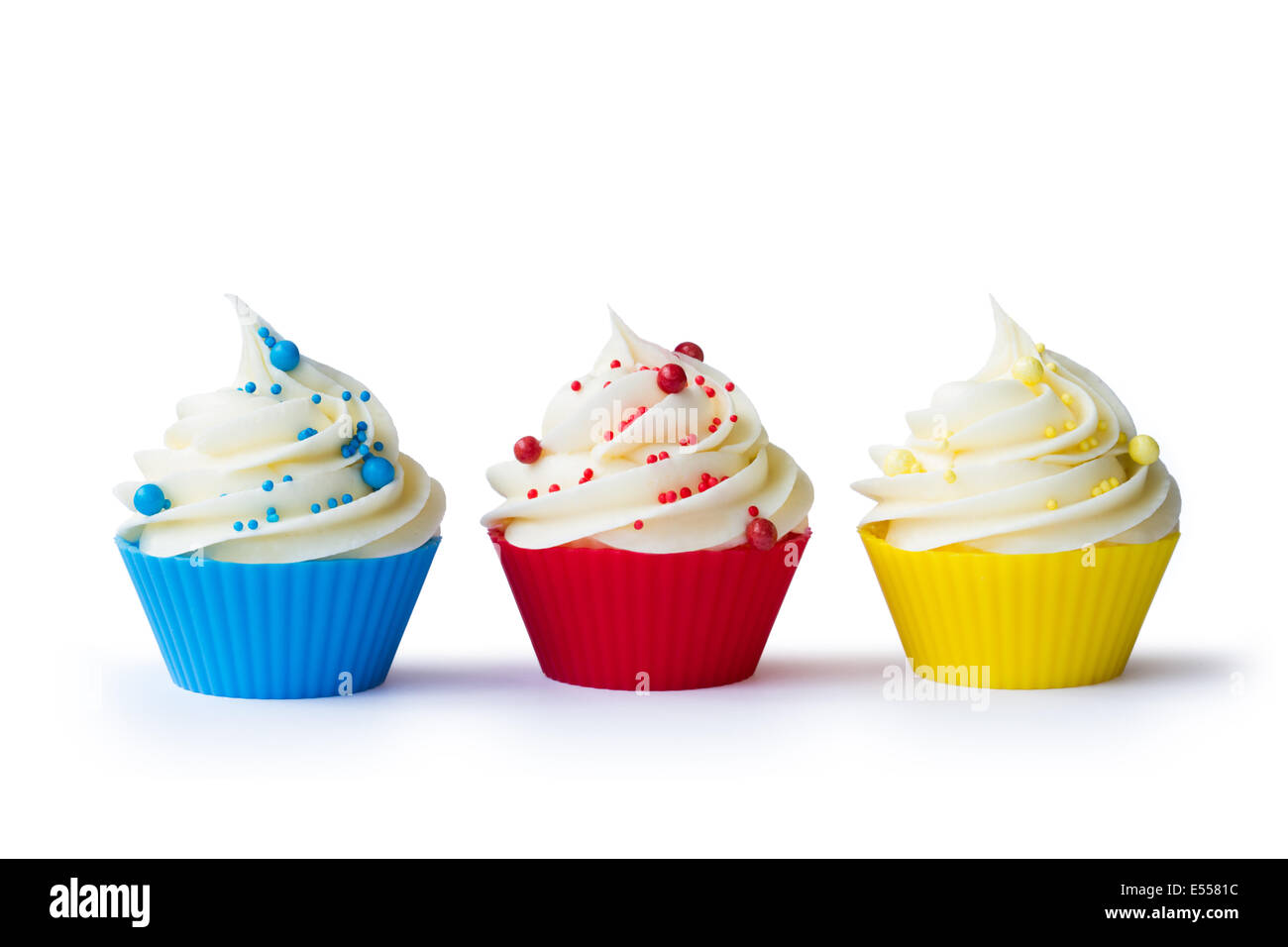 Drei bunte Cupcakes isoliert gegen weiß Stockfoto