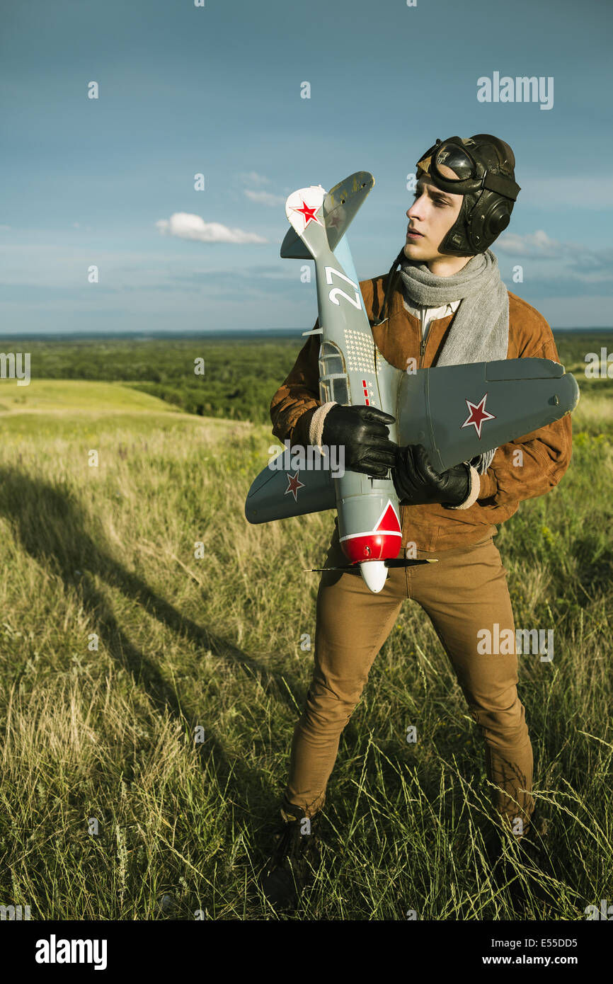 Junger Kerl in Vintage-Kleidung-Pilot mit einem Flugzeug Modell im freien Stockfoto