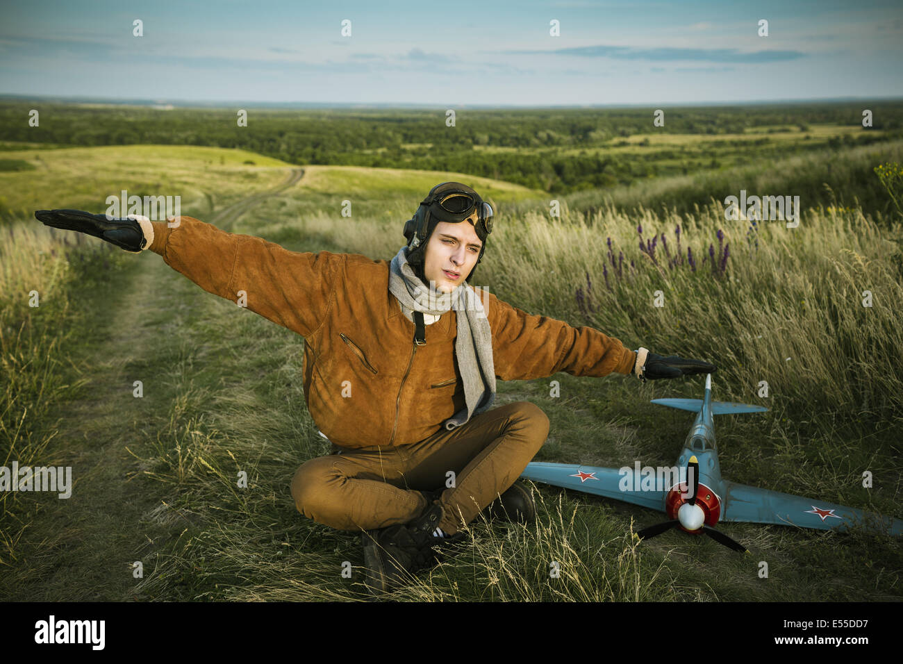 Junger Kerl in Vintage-Kleidung-Pilot mit einem Flugzeug Modell im freien Stockfoto