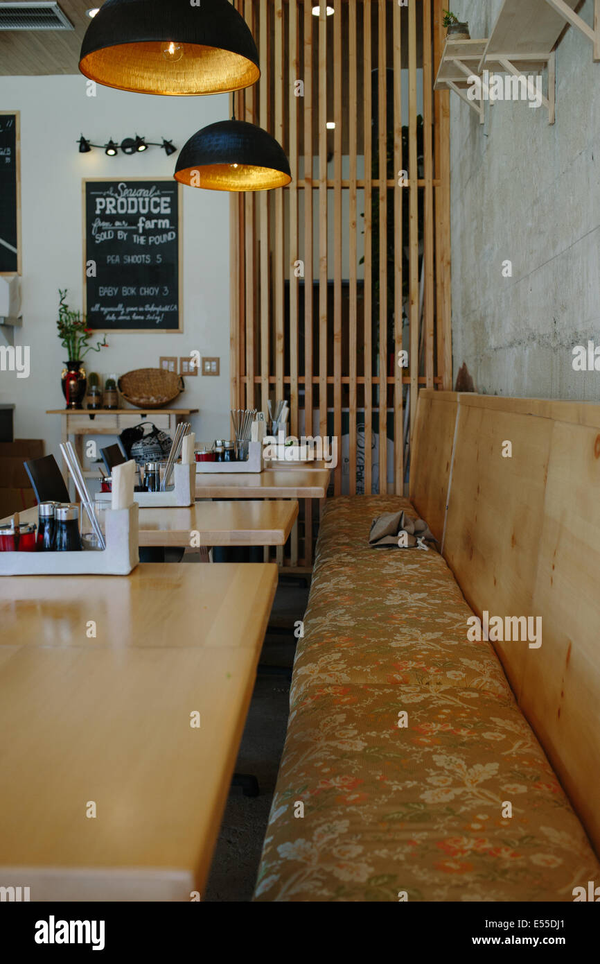 Perspektive-Schuss von einer langen Bank gegen eine Wand in einem Restaurant mit ungezwungener Atmosphäre. Stockfoto