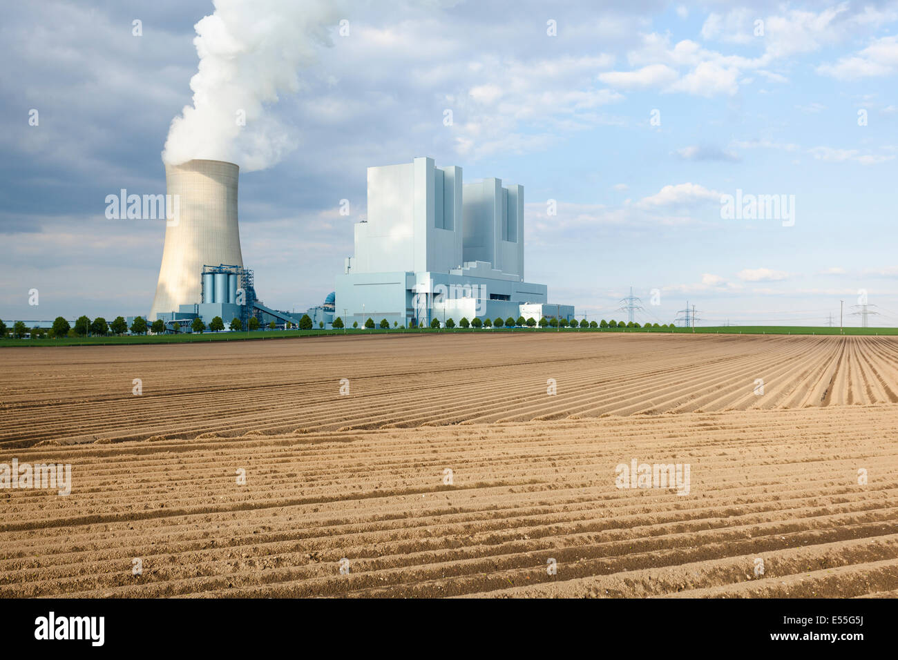Ein glänzendes neues Braunkohle Kraftwerk hinter ein leeres Feld Stockfoto