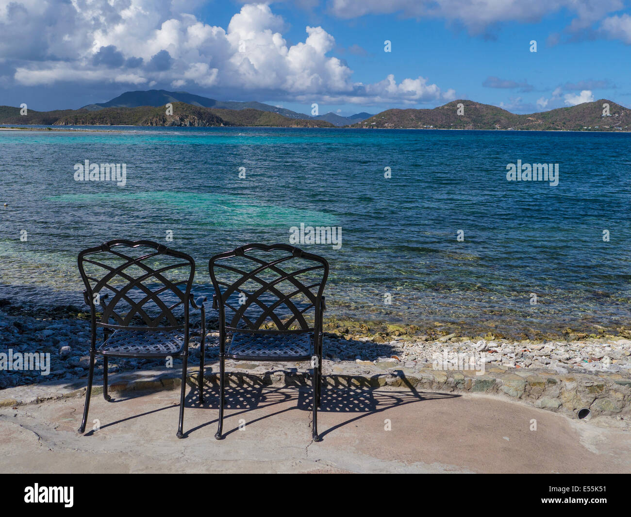 Zwei leere Stühle am Strand am Rand des Wassers von Coral Bay auf der Karibik Insel St. John in den US Virgin Islands Stockfoto