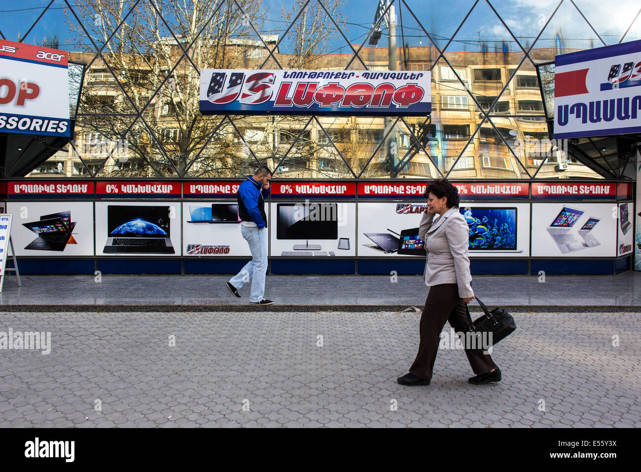 Fußgänger passieren während des Gesprächs in Mobiltelefonen in Yerevan, Armenien Stockfoto