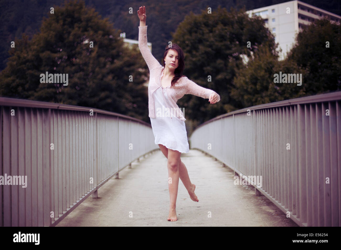 Junge Frau tanzen barfuß auf einer Brücke Stockfoto