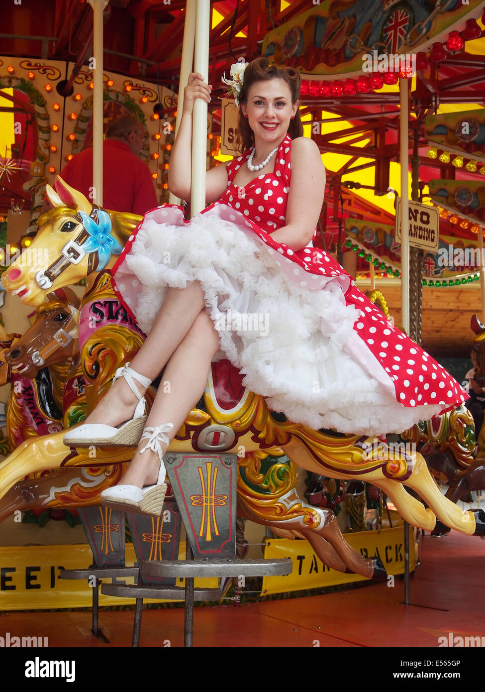 Mädchen in einem roten Polka Dot Kleid auf einem Karussell Stockfoto