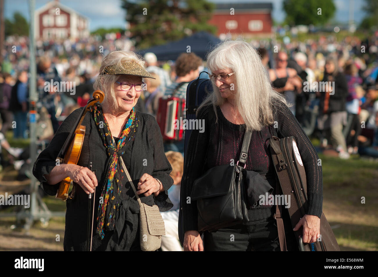 Zwei lächelnde Musikerinnen auf dem berühmten traditionellen Volksmusikfestival in Bingsjo, Schweden. Stockfoto