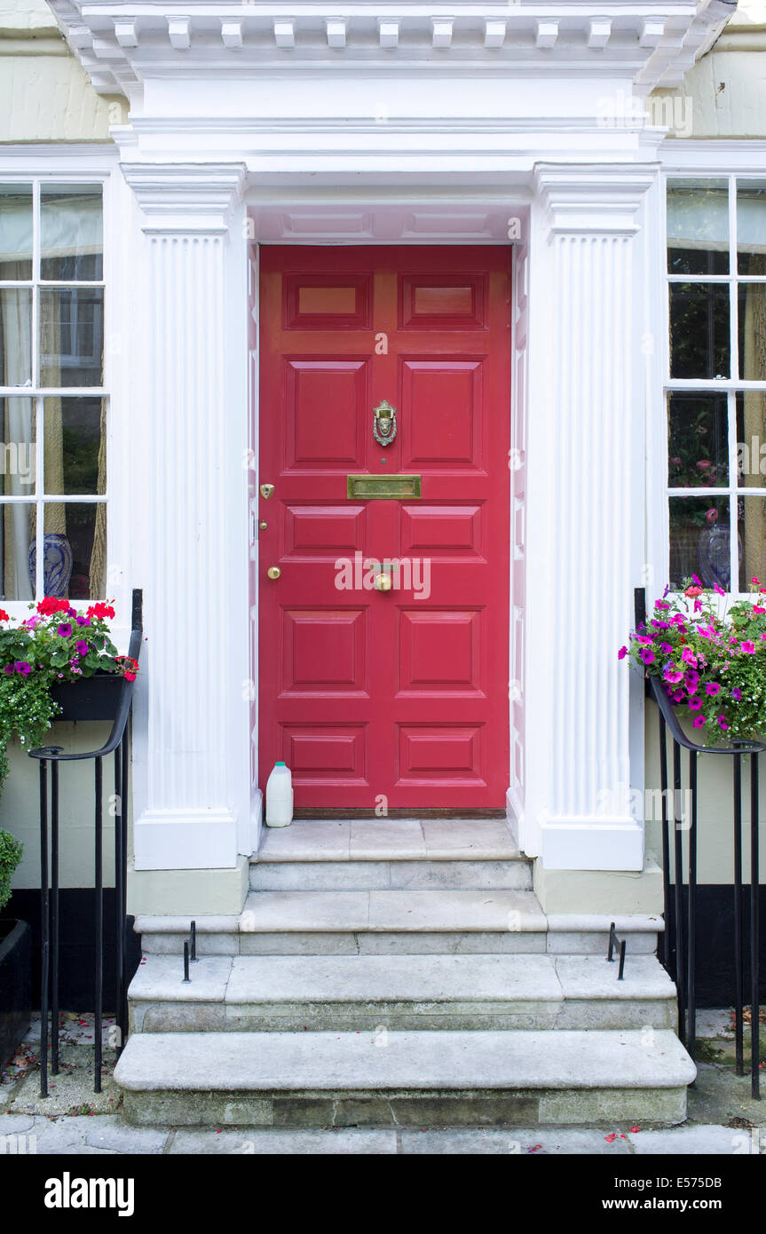 UK-Eingangstür zum Haus mit Steinstufen und Milchflasche auf Schritt Stockfoto