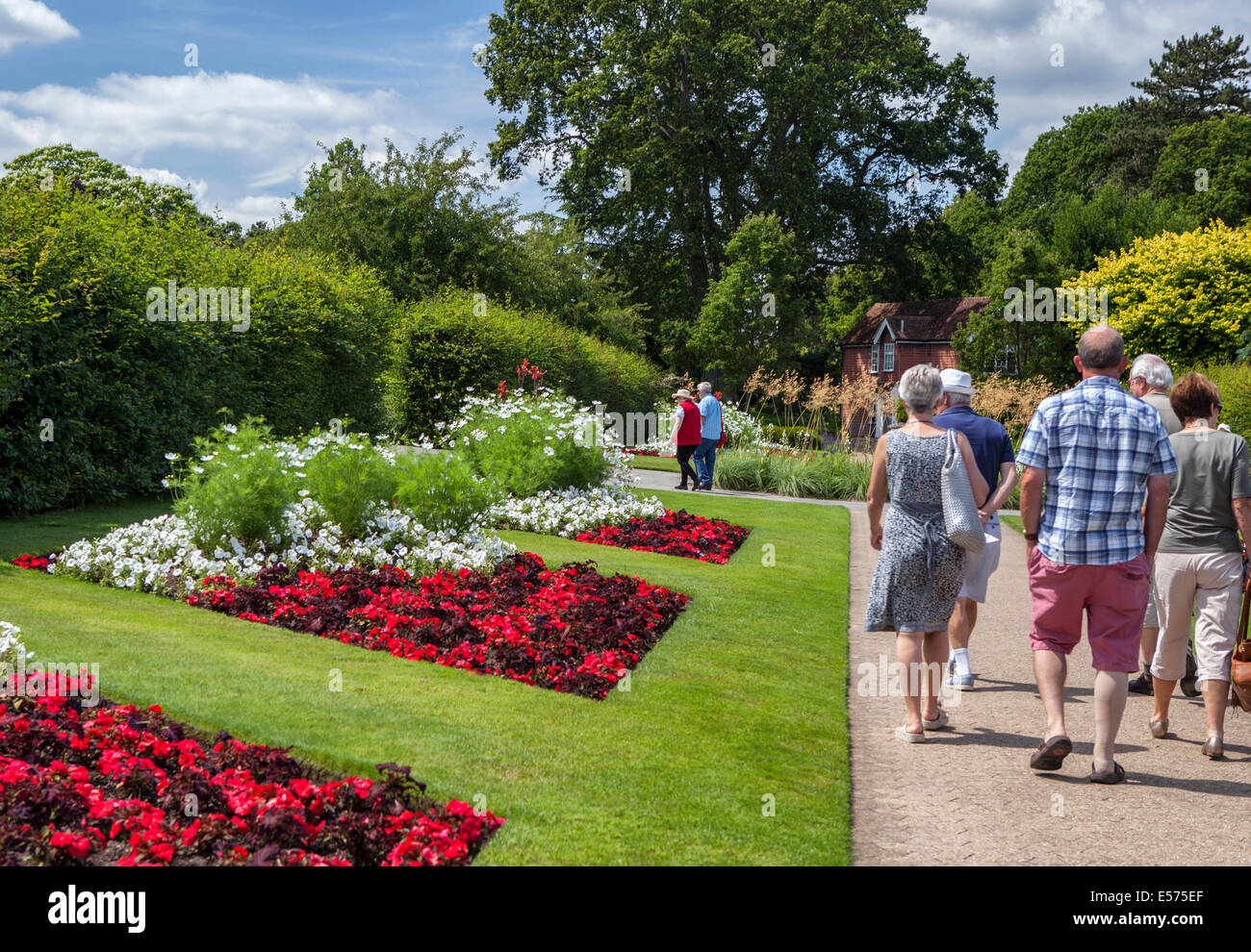 Menschen zu Fuß vorbei an bunten roten und weißen Blumenbeete in Wisley RHS Gardens, Surrey Stockfoto