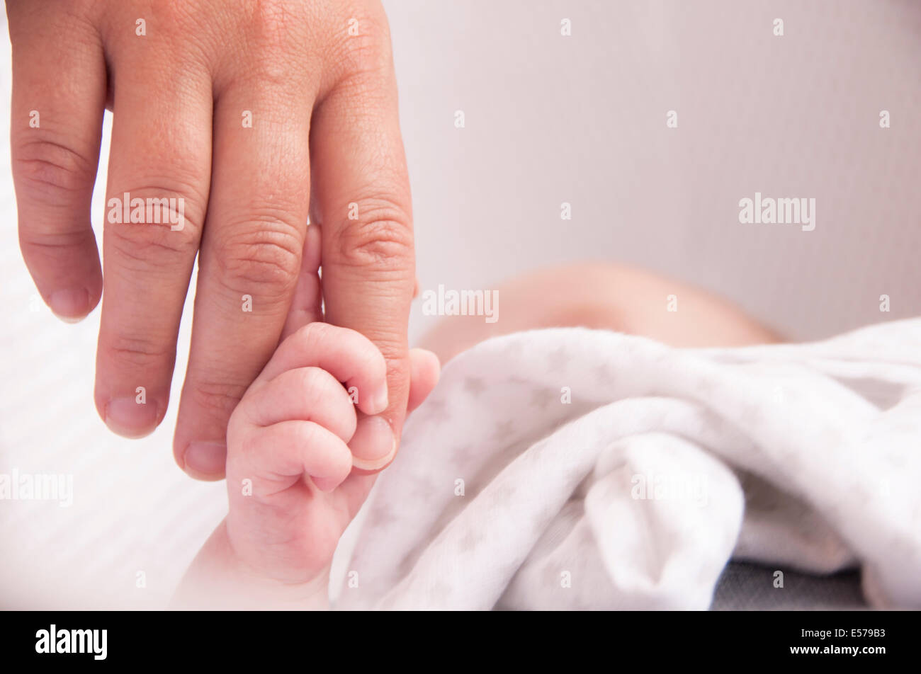 Baby halten Mütter Hand für die Sicherheit in seinem Kindergarten Stockfoto