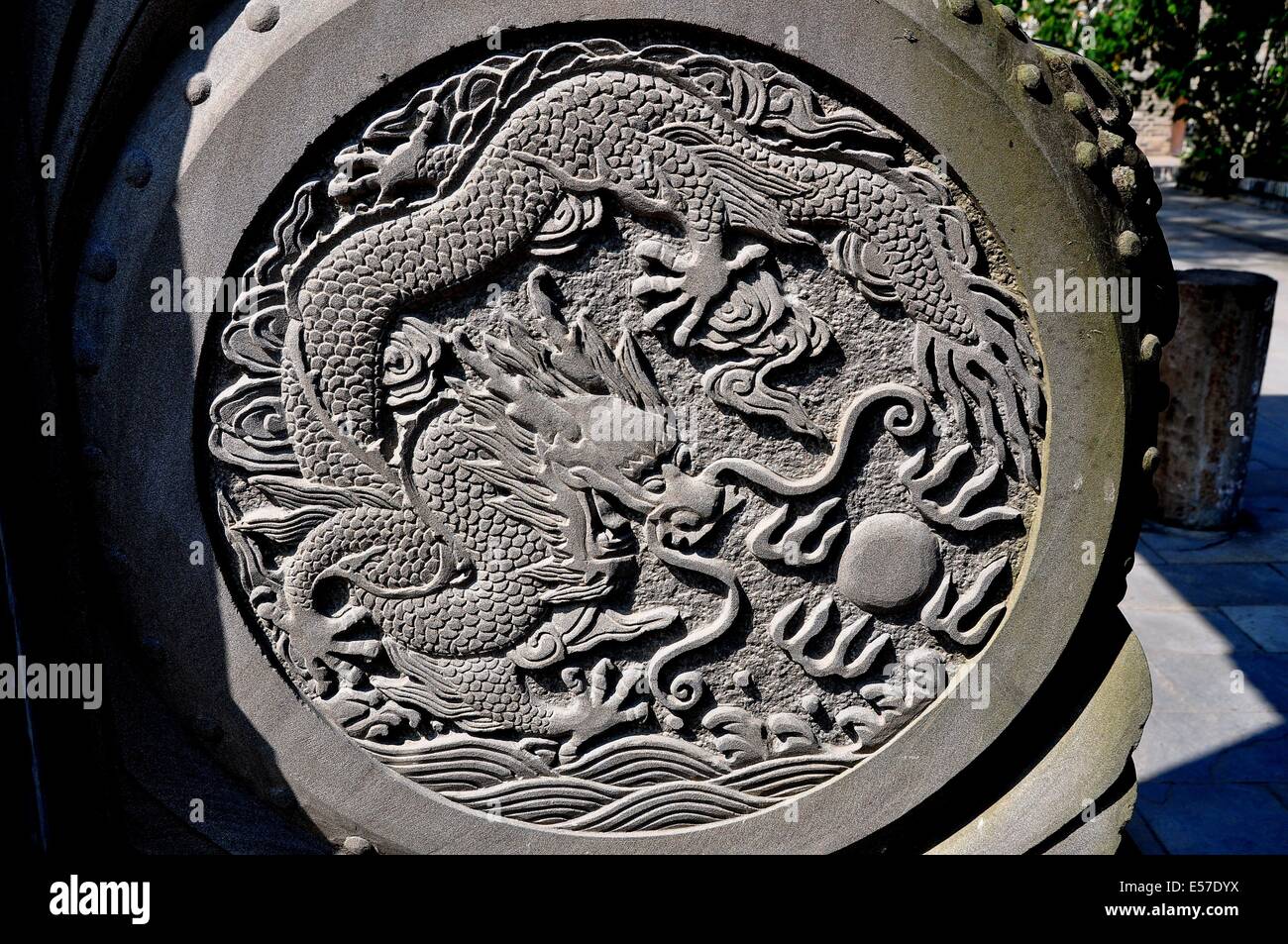 XIN XING TOWN, CHINA: Ein Stein Medaillon mit geschnitzten Drachen Figur auf der Basis der zeremoniellen Eingangstor Stockfoto