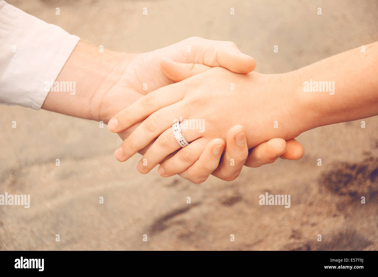 Halten die Hände am Strand, ein neu Brautpaar zeigt ihren Verlobungsring Stockfoto