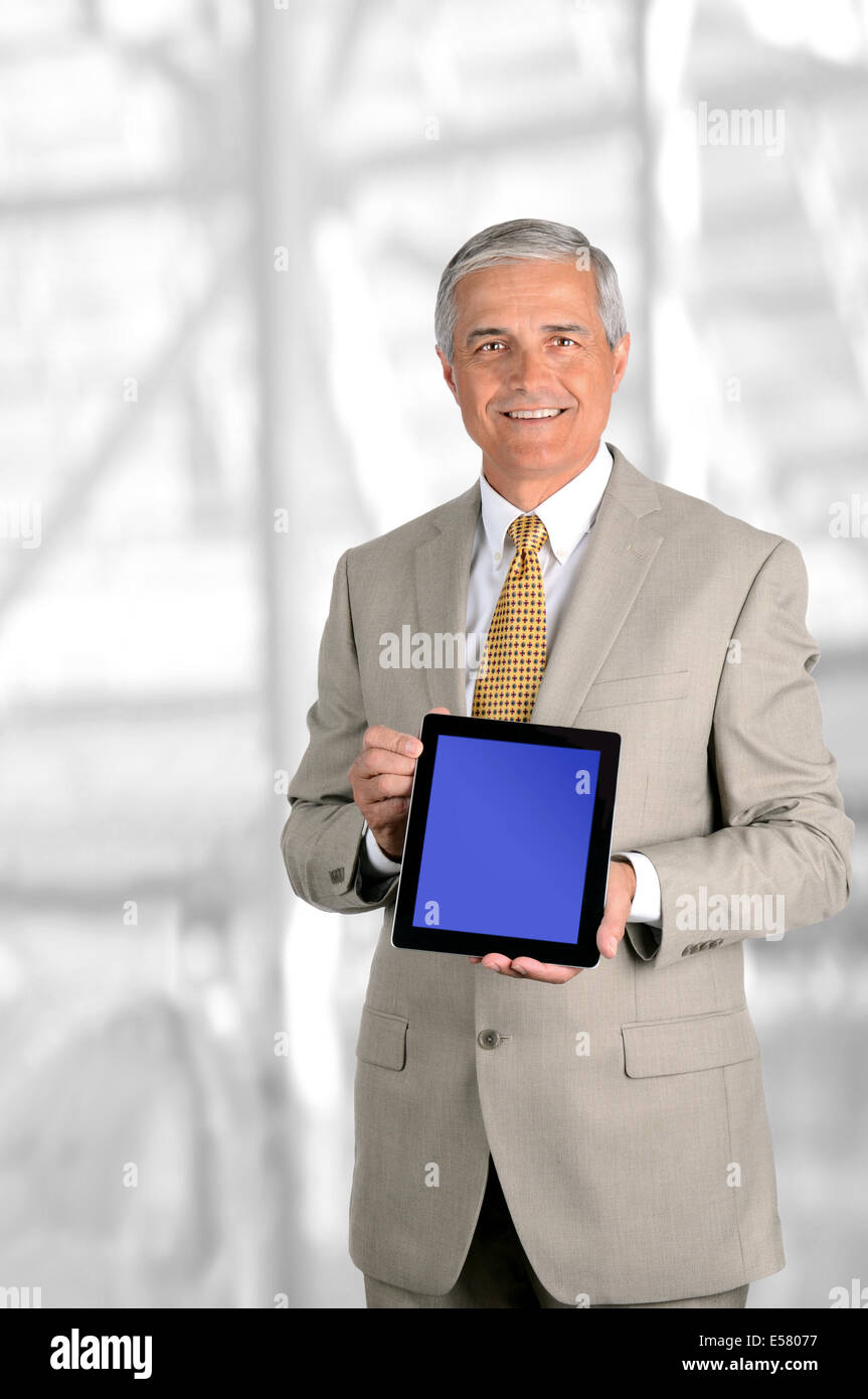 Ein reifer Geschäftsmann hält einen Tablet-PC mit Bluescreen nach vorne. Einfach Bildschirm fügen Sie Ihre eigene Grafik ersetzen. Stockfoto