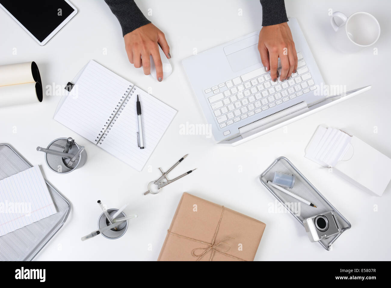 Hohen Winkel Aufnahme einer Frau aus ihrem home-Office arbeiten. Nur ihre Hände sind sichtbar, wie sie auf ihrem Laptop-Computer eingibt. Der Witz Stockfoto