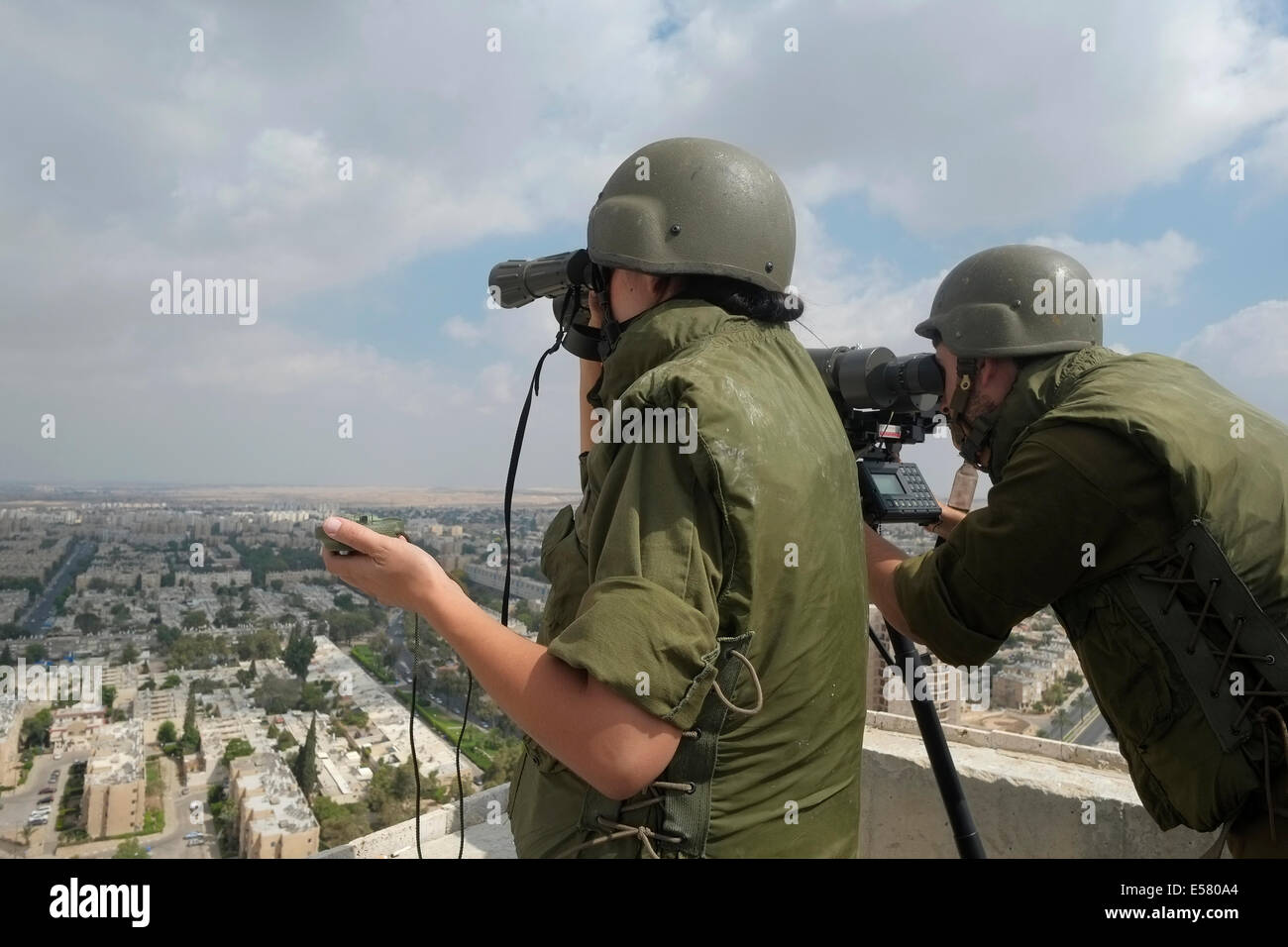 Israelische Soldaten aus dem Bereich Intelligence Corps Beerscheba Skyline mit dem Fernglas Scannen an Standorten, die durch Raketen aus dem Gazastreifen abgefeuert wurden getroffen. Das Feld Intelligence Corps, ist für das Sammeln von visuellen Informationen auf dem Schlachtfeld und es schnell übertragen auf andere Kräfte verantwortlich. Stockfoto