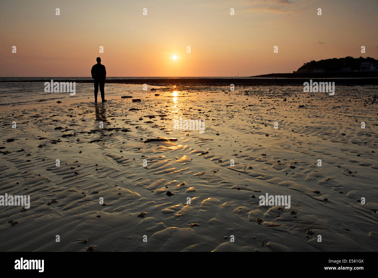 Whitstable, Kent, UK 23. Juli 2014. Morgendämmerung am Whitstable als der Sonnenaufgang leuchtet eine Gehhilfe und einige Wellen im Sand. Das Wetter wird sich voraussichtlich für die nächsten paar Tage warm und sonnig sein, aber mit möglichen Duschen für das Wochenende. Stockfoto