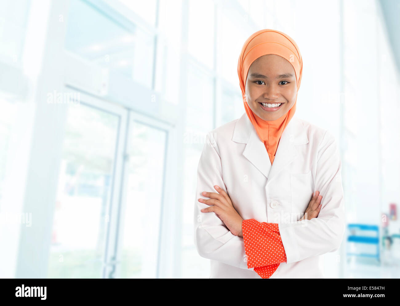 Fröhliche junge muslimische Krankenschwester Porträt, stehend im Krankenhaus Stockfoto