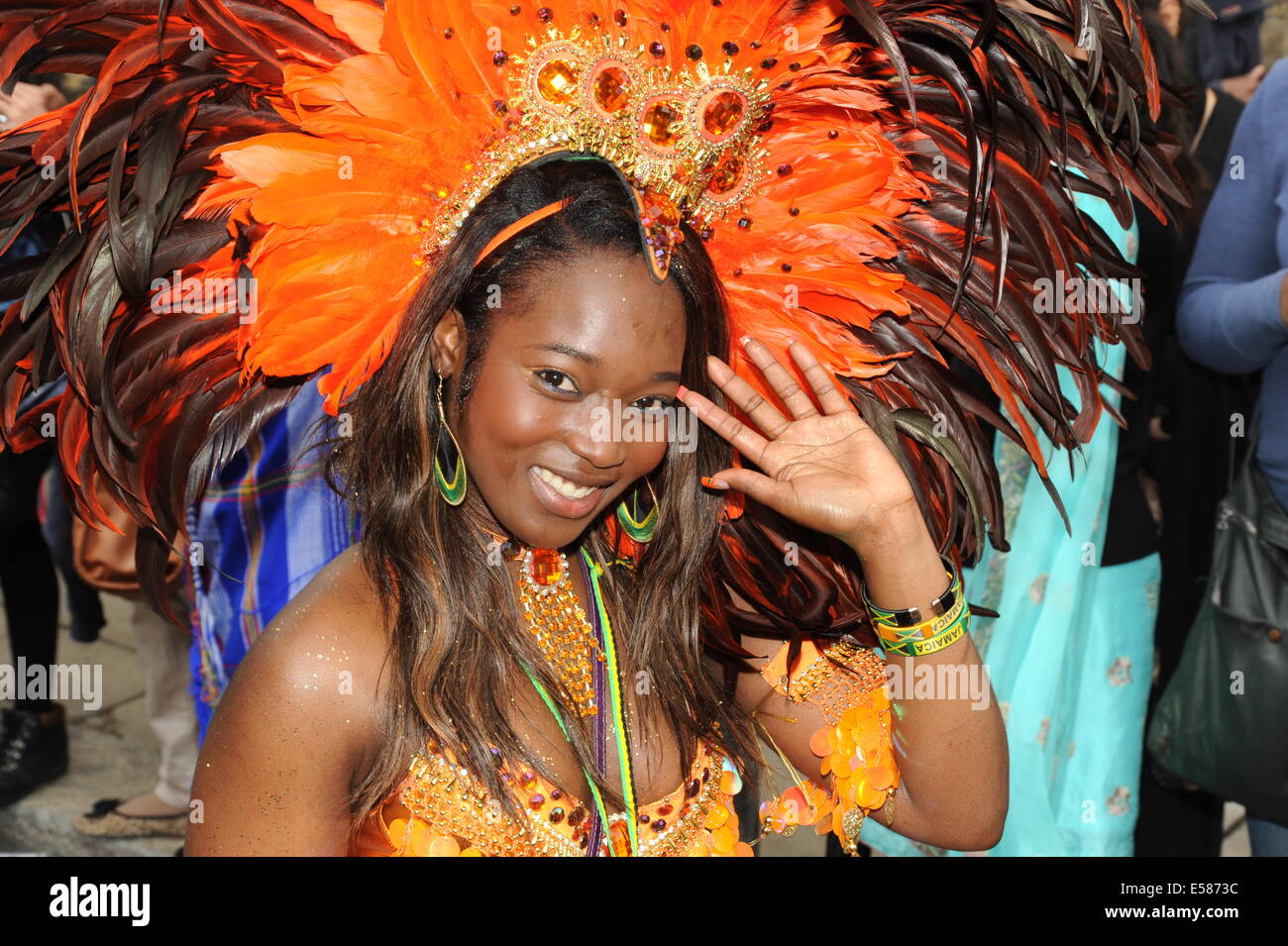 Foto einer Frau in Notting Hill Carnival tragen traditionelle karibische Kopfschmuck winken in die Kamera Stockfoto