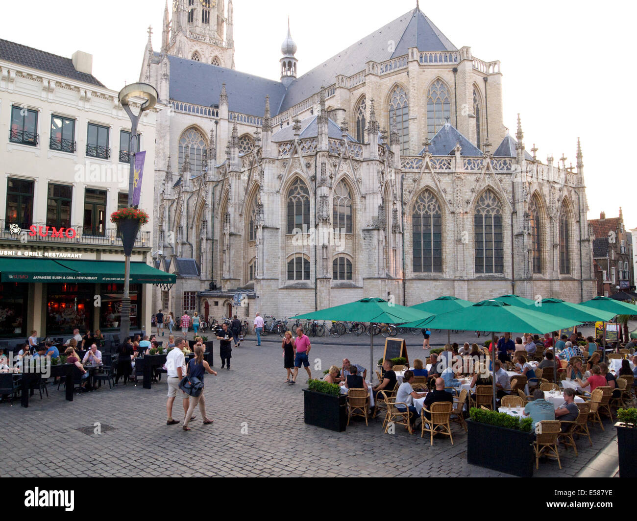 Sommerabend in Breda, Niederlande, mit vielen Menschen, die Essen im Freien auf dem Grote Markt Platz, und die große Kirche Stockfoto
