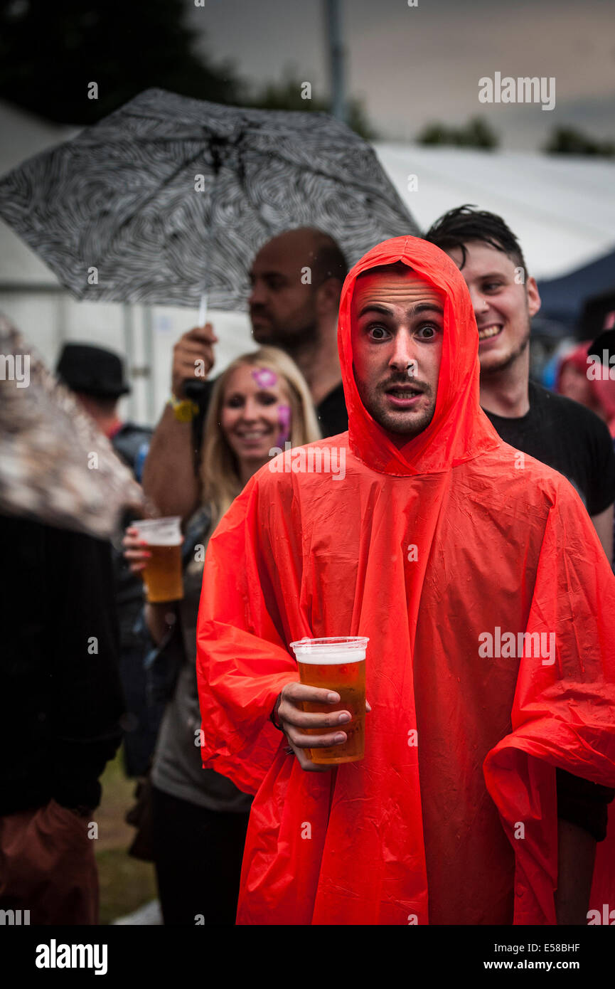 Ein Festbesucher mit einem roten Poncho aus Plastik beim Brentwood Festival.in Essex in Großbritannien Stockfoto