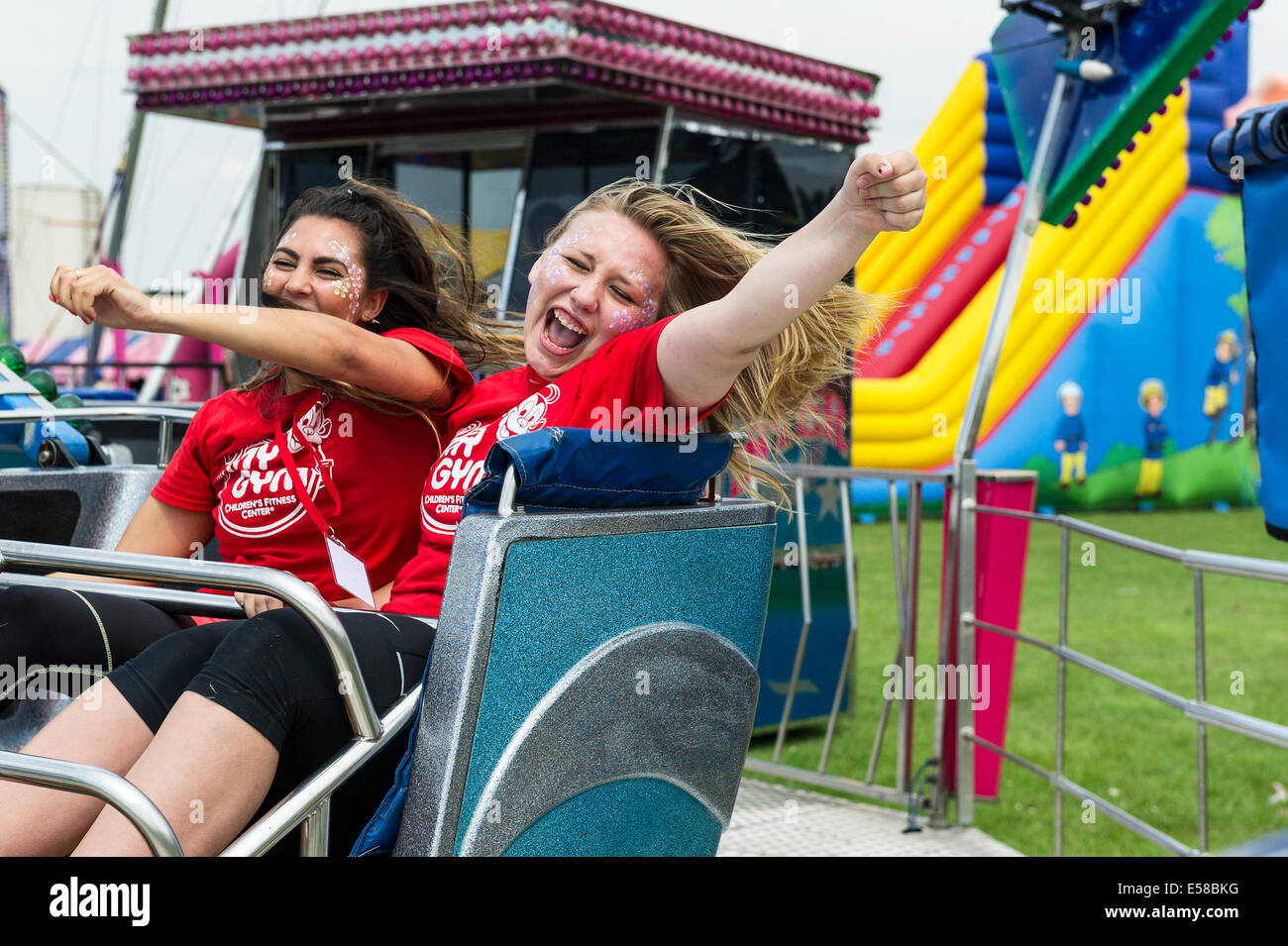 Zwei junge Mädchen genießen sich auf einem Festplatz beim Brentwood Festival in Essex. Stockfoto