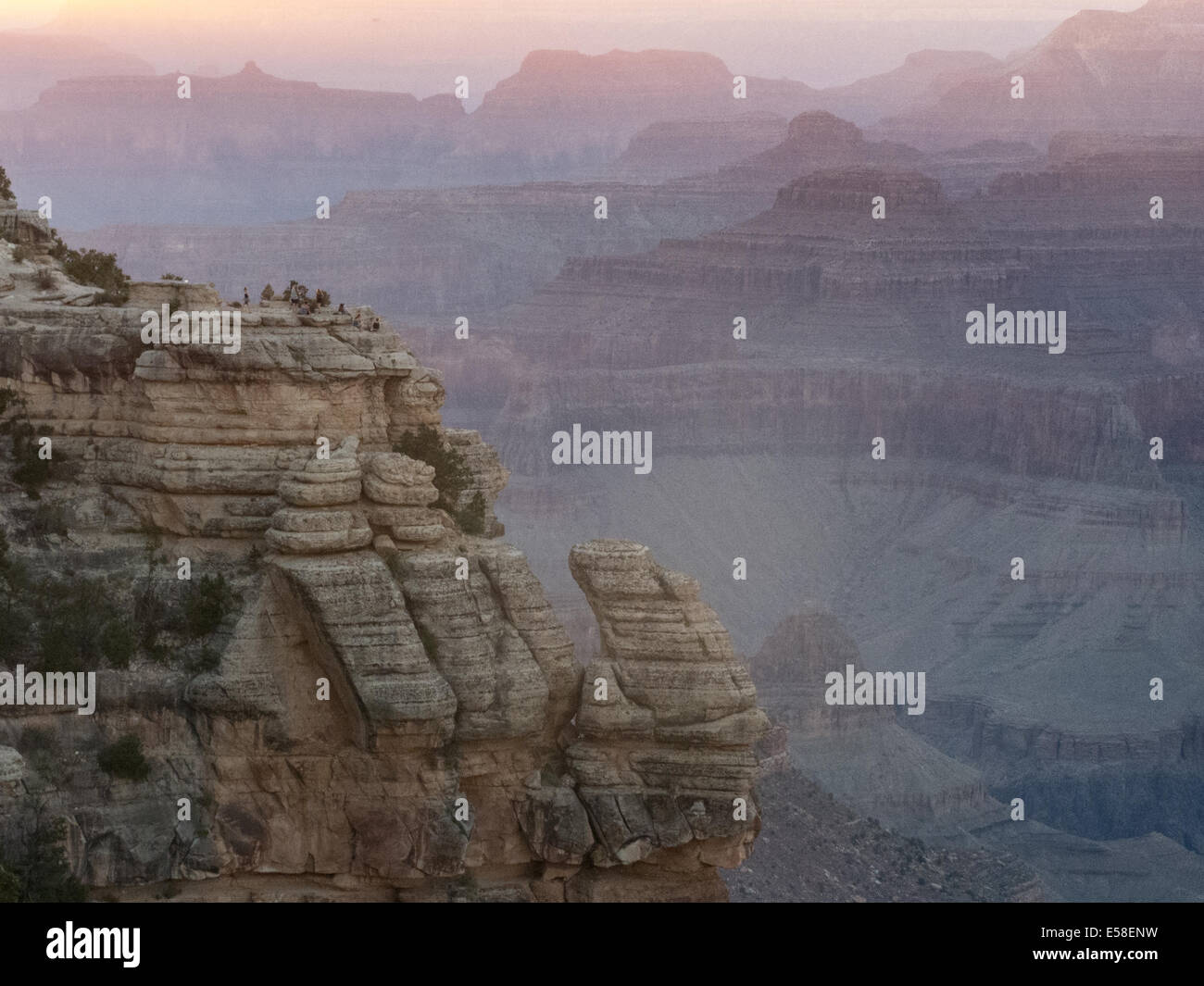 Besucher genießen Sie den Sonnenuntergang über dem Grand Canyon (Arizona, USA) von den unheimlichen Klippen des South rim Stockfoto