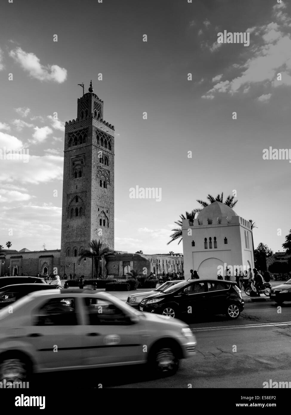 Die verkehrsreichen von Marrakesch saust um den stattlichen Koutoubia-Moschee und dem hoch aufragenden Minarett Stockfoto