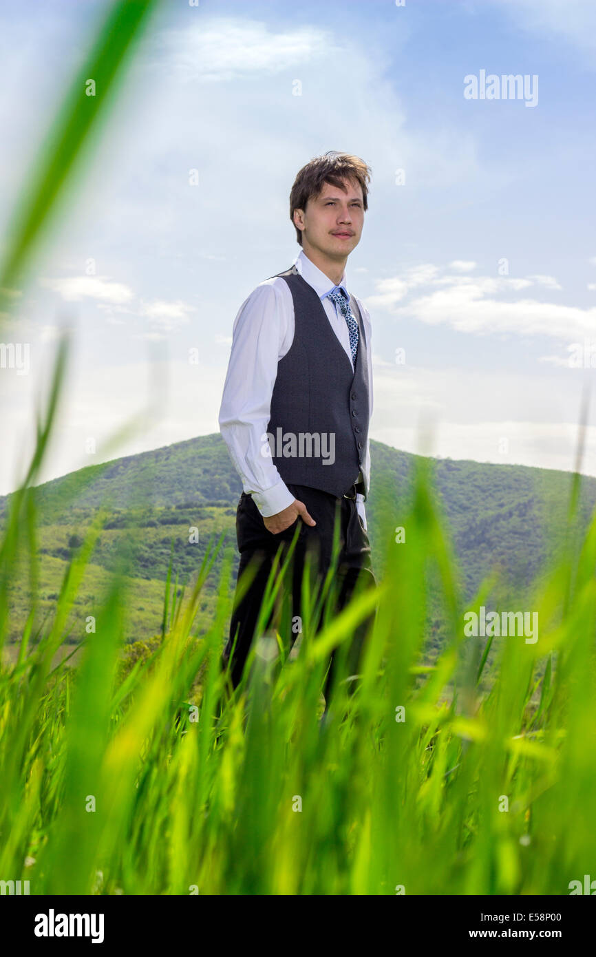 Junger Geschäftsmann, lange Spaziergänge in der Natur, entspannen und nachdenken. Hände in den Taschen, selektiven Fokus Stockfoto