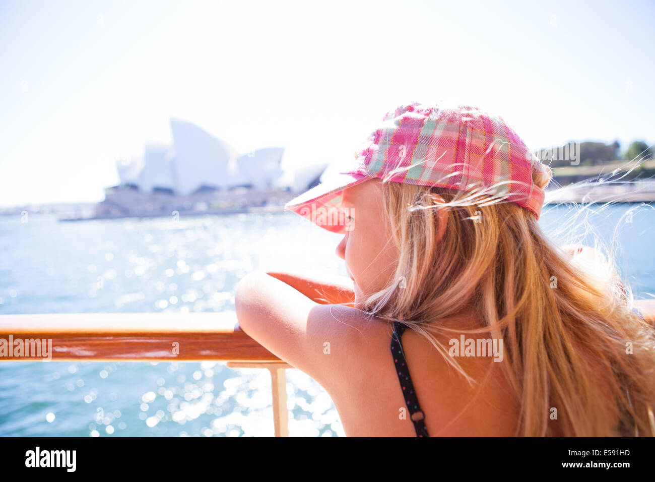 Junge blonde Mädchen stützte sich auf Fähre Geländer und Blick auf Websites mit der Oper von Sydney im Hintergrund Stockfoto