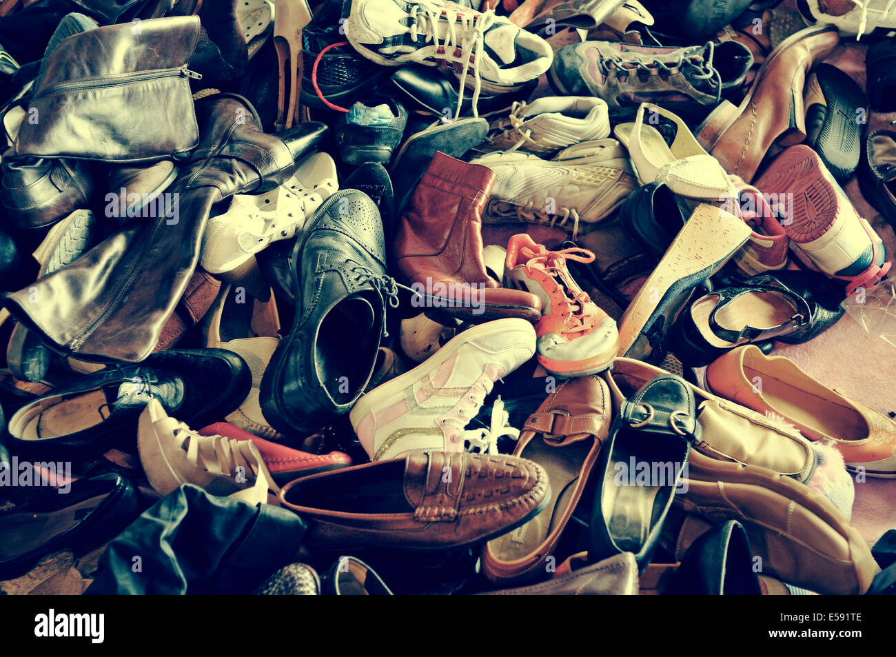 ein Haufen von zweiter Hand Schuhe auf einem Flohmarkt mit einem Retro-Filtereffekt Stockfoto