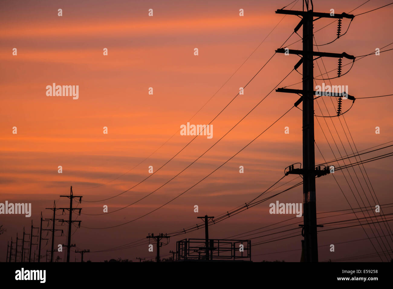 Strom Kabel Kommunikation erhebt sich am Sonnenuntergang erstreckt sich über den Fluss. Stockfoto