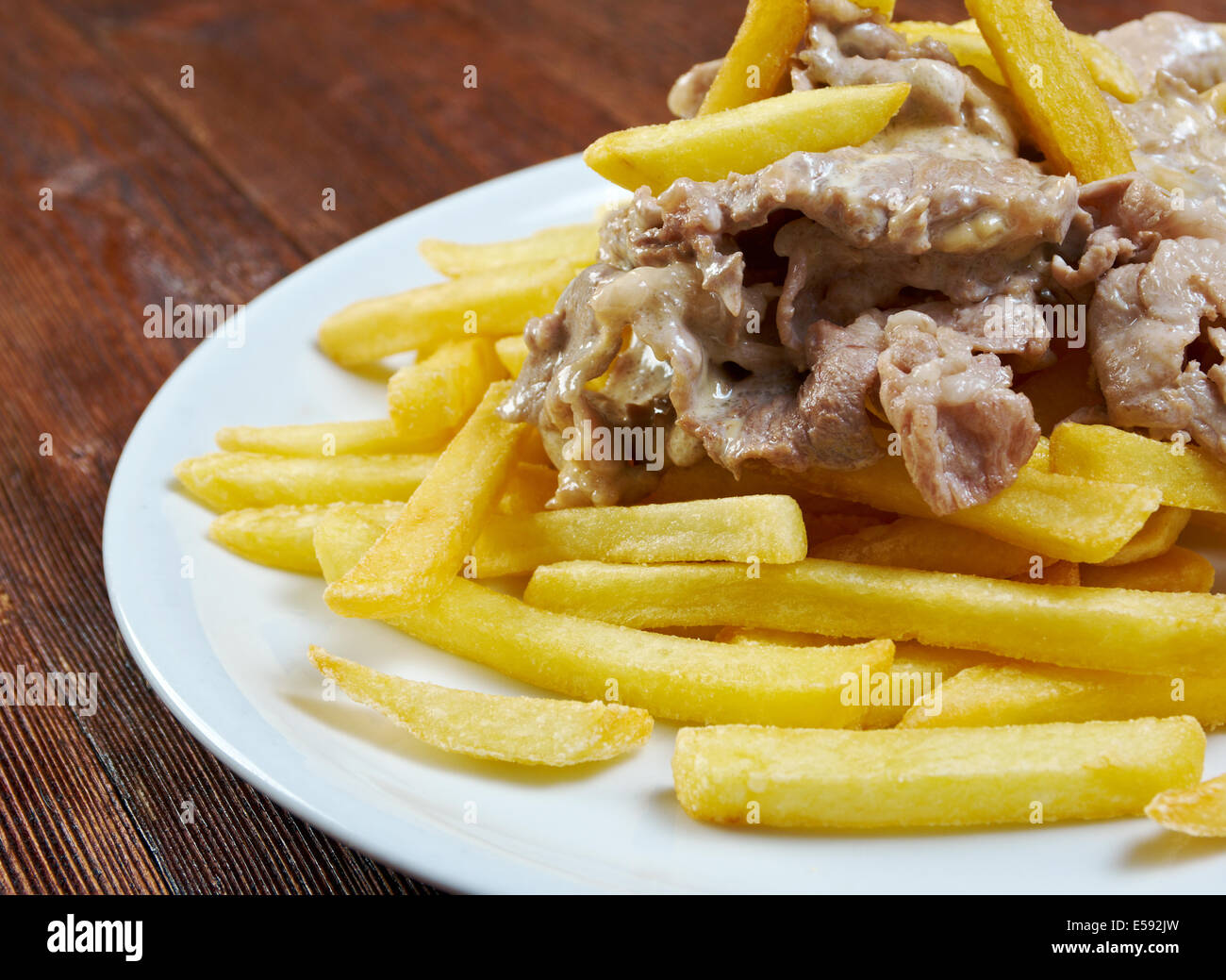 Schneiden Sie Schweinefleisch mit Pommes frites in Scheiben. Nahaufnahme Stockfoto