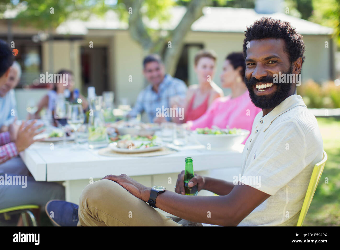 Mann lächelnd am Tisch im freien Stockfoto