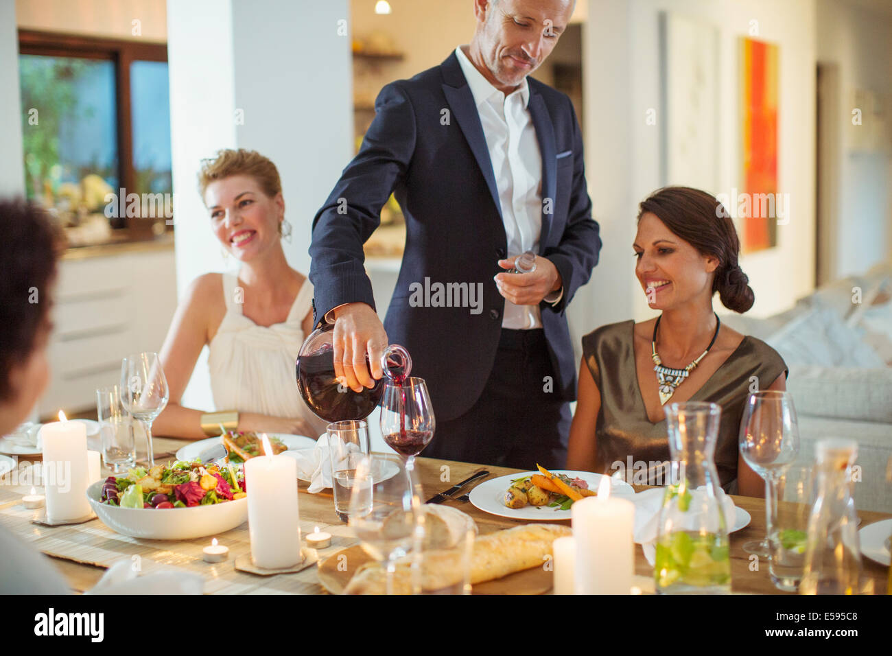 Man gießt Wein bei Dinner-party Stockfoto