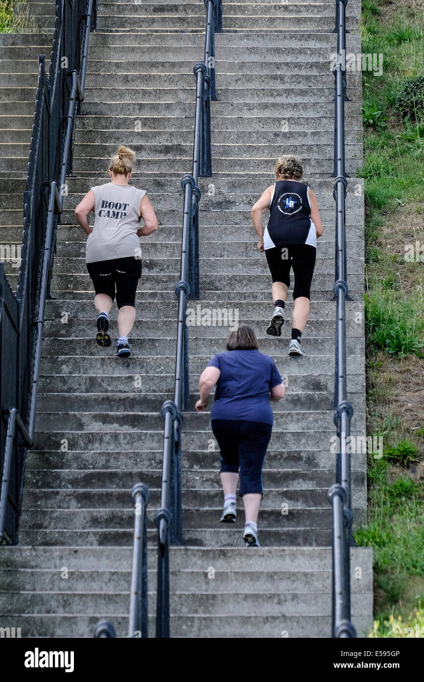 Frauen, die eine Reihe von steilen Treppen hochlaufen. Stockfoto