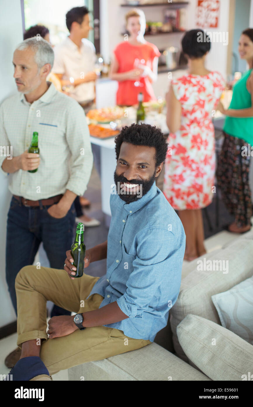 Mann lächelnd auf Sofa auf party Stockfoto