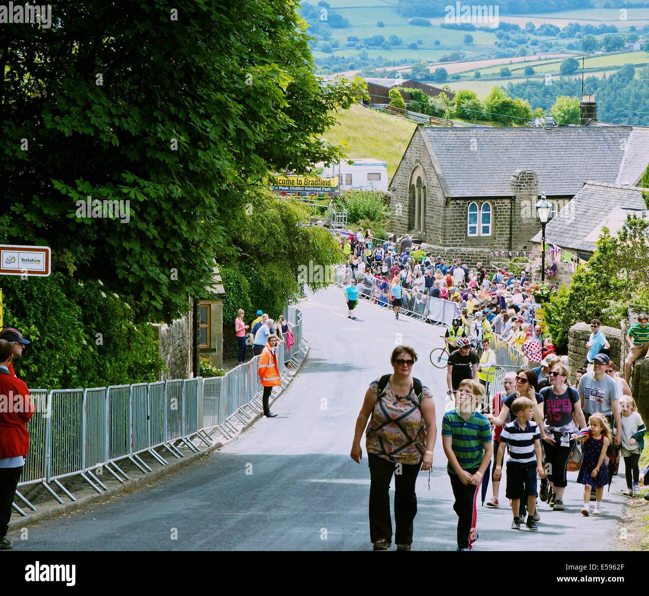 Zuschauer, die zu Fuß zu Aussichtspunkten auf die Strecke der Tour de France durch die Ortschaft hohe Bradfield South Yorkshire England Stockfoto